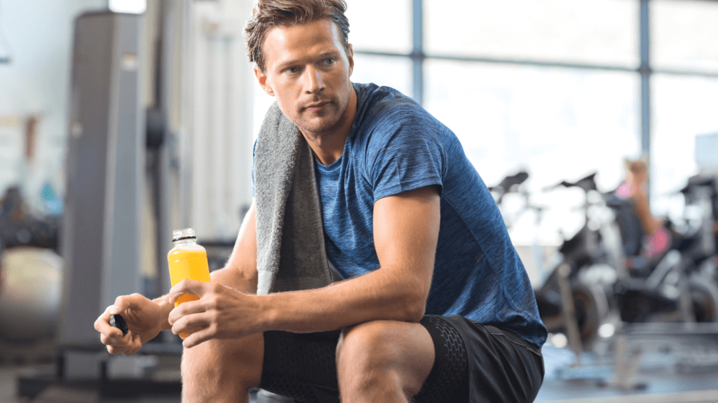 A man in a gym holding a sports drink