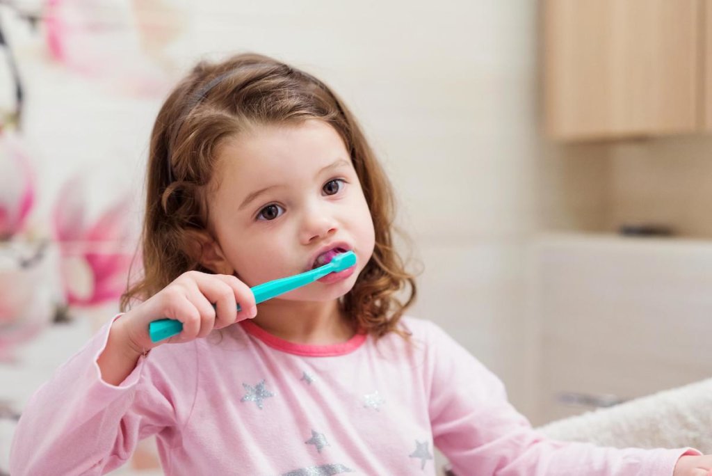 little girl brushing her teeth