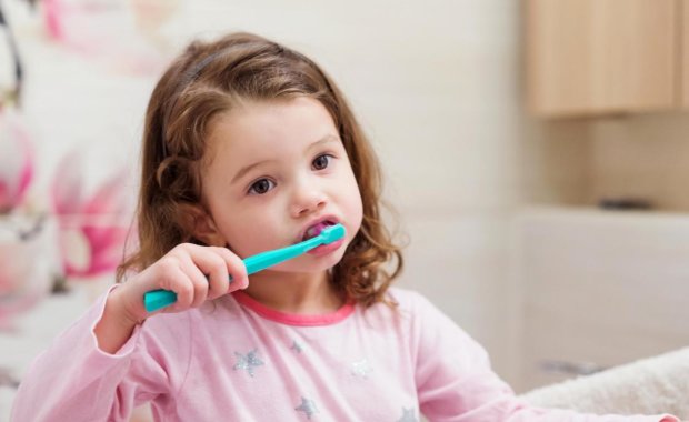 little girl brushing her teeth